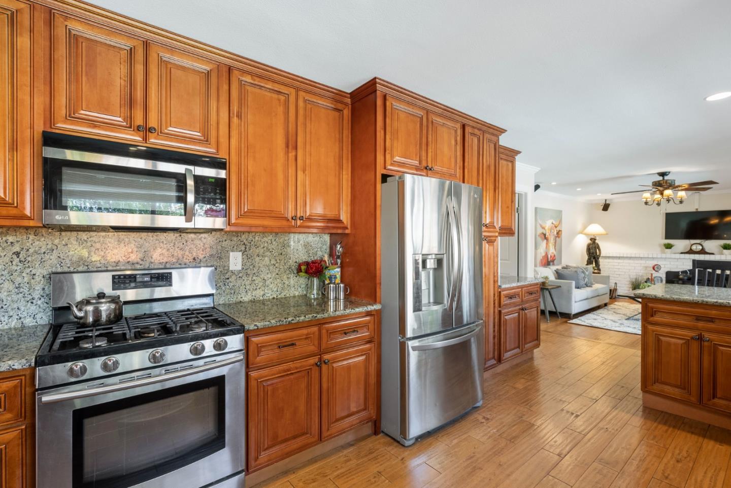 6570 Thames Drive Gilroy, CA 95020 - Photo 5 of 30 a kitchen with granite countertop a refrigerator stove and wooden floor