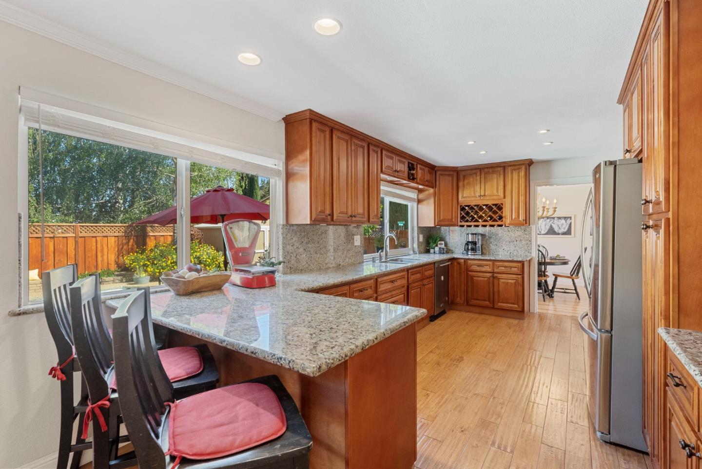 6570 Thames Drive Gilroy, CA 95020 - Photo 7 of 30 a kitchen with granite countertop a dining table chairs sink and wooden floor