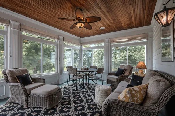a bedroom with a bed couch chandelier and window