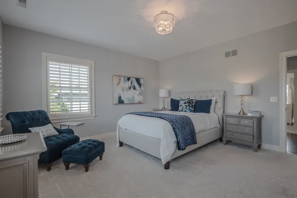 a bedroom with a large bed and a chandelier
