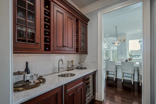a large kitchen with a large island in the center a sink a window cabinets and stainless steel appliances