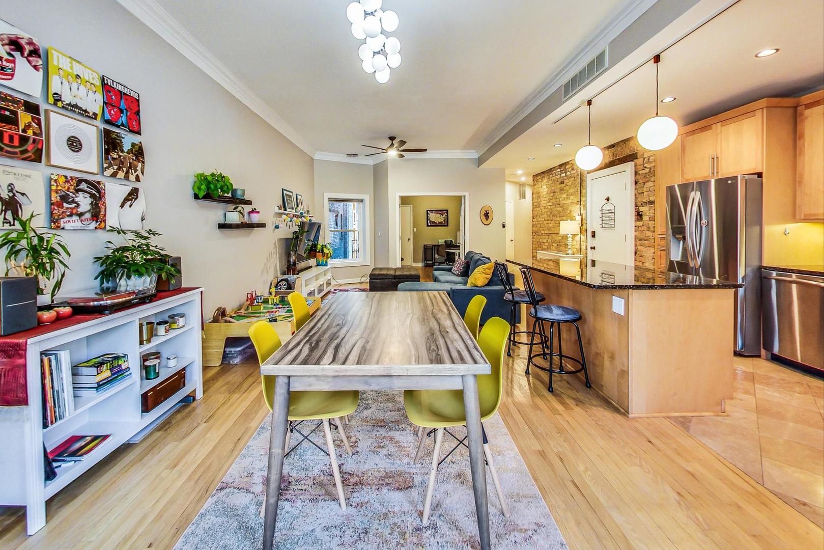 4061 North Sheridan Road, Unit 1 Chicago, IL 60613 - Photo 12 of 26 a living room with furniture and a dining table with wooden floor
