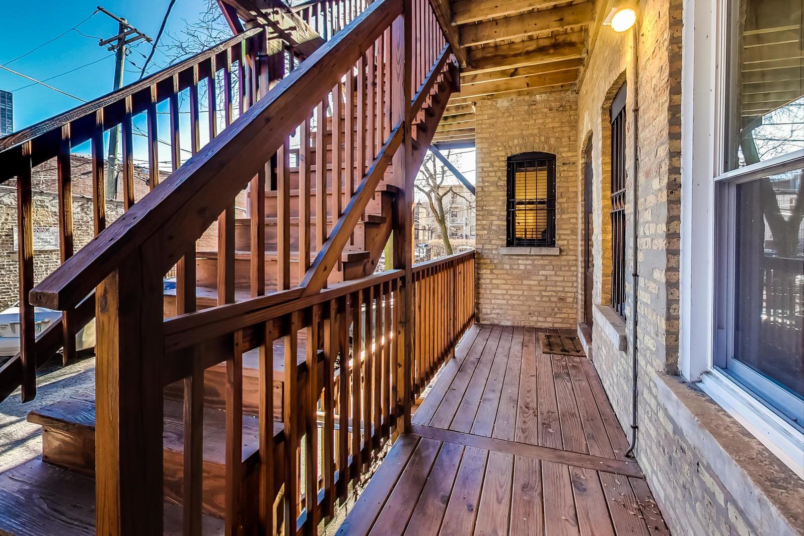 4061 North Sheridan Road, Unit 1 Chicago, IL 60613 - Photo 25 of 26 a view of staircase with wooden floor and a floor to ceiling window