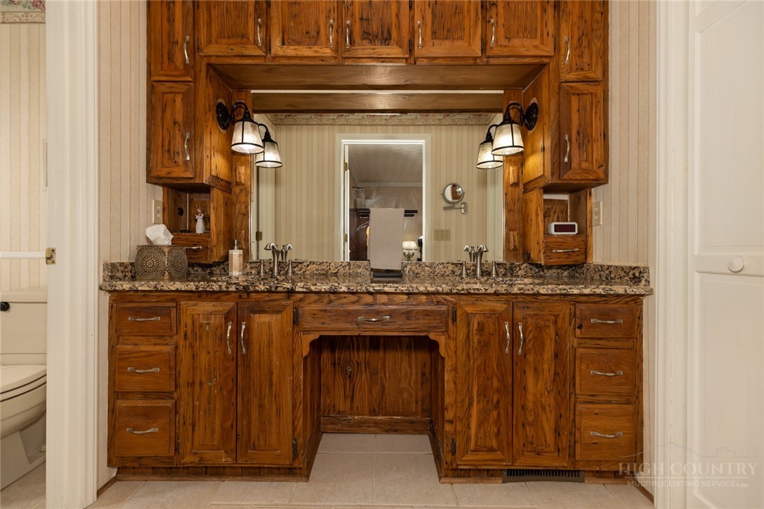 1335 Shingle Gap Road Purlear, NC 28665 - Photo 25 of 49 a bathroom with a granite countertop sink a mirror and a vanity