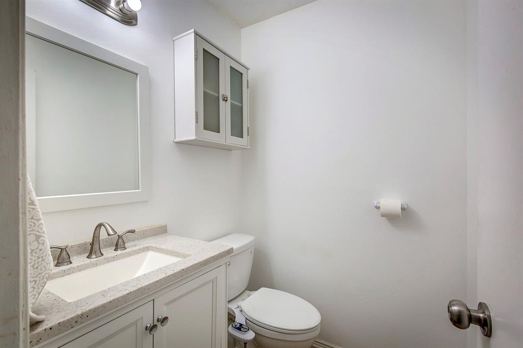 307 East McCoulskey Street Terrell, TX 75160 - Photo 11 of 16 a bathroom with a granite countertop toilet sink and mirror