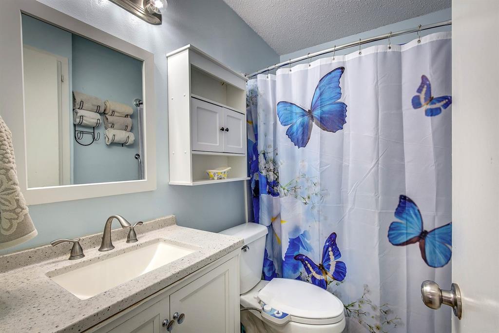 307 East McCoulskey Street Terrell, TX 75160 - Photo 13 of 16 a bathroom with a sink toilet and shower curtain