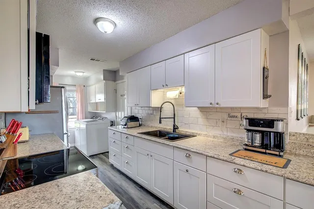a kitchen with a sink stove and cabinets