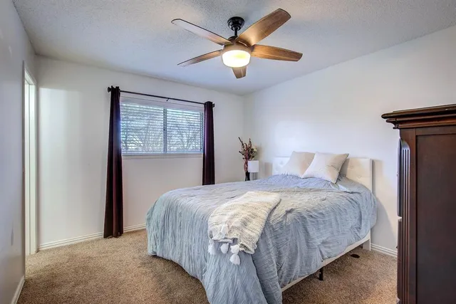a bedroom with a bed and a ceiling fan