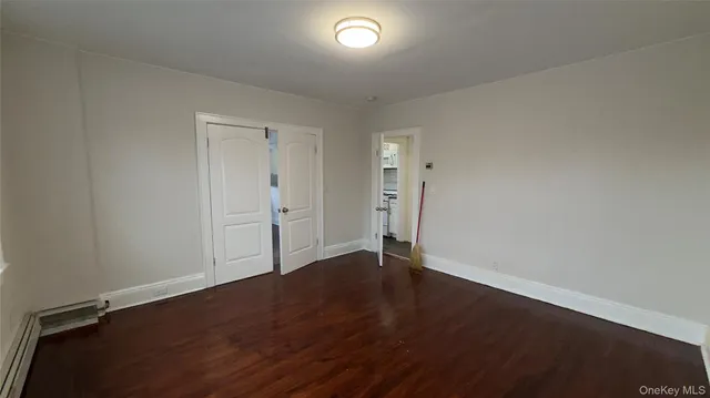 an empty room with wooden floor and a window