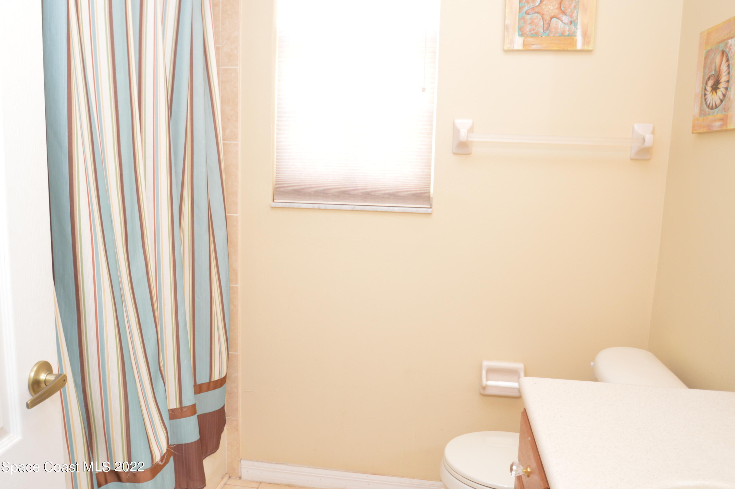 274 Intrepid Way Indialantic, FL 32903 - Photo 22 of 23 a white toilet sitting next to a shower curtain