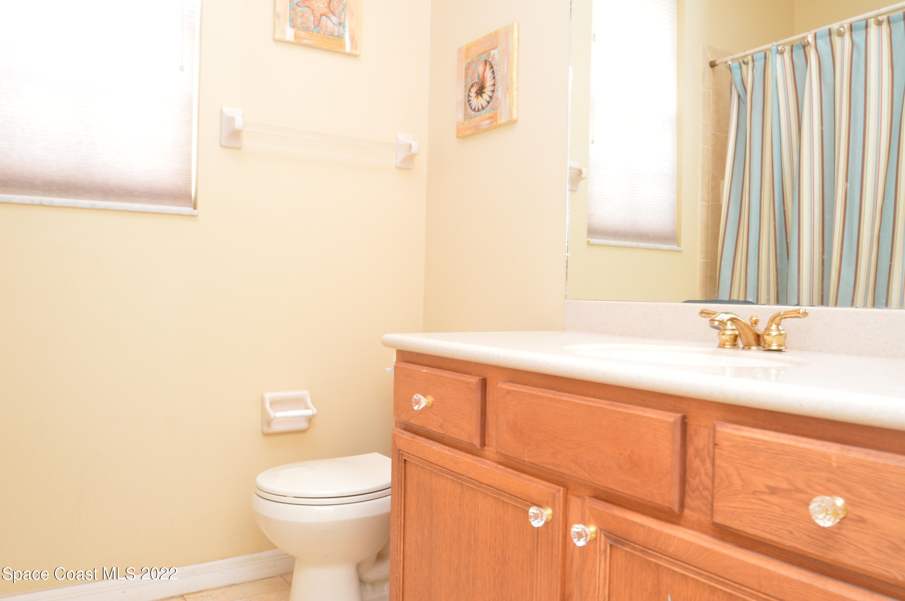 274 Intrepid Way Indialantic, FL 32903 - Photo 23 of 23 a bathroom with a sink a toilet and a mirror