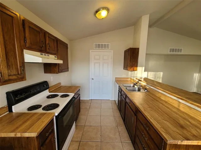 a kitchen with stainless steel appliances a sink a stove and a refrigerator