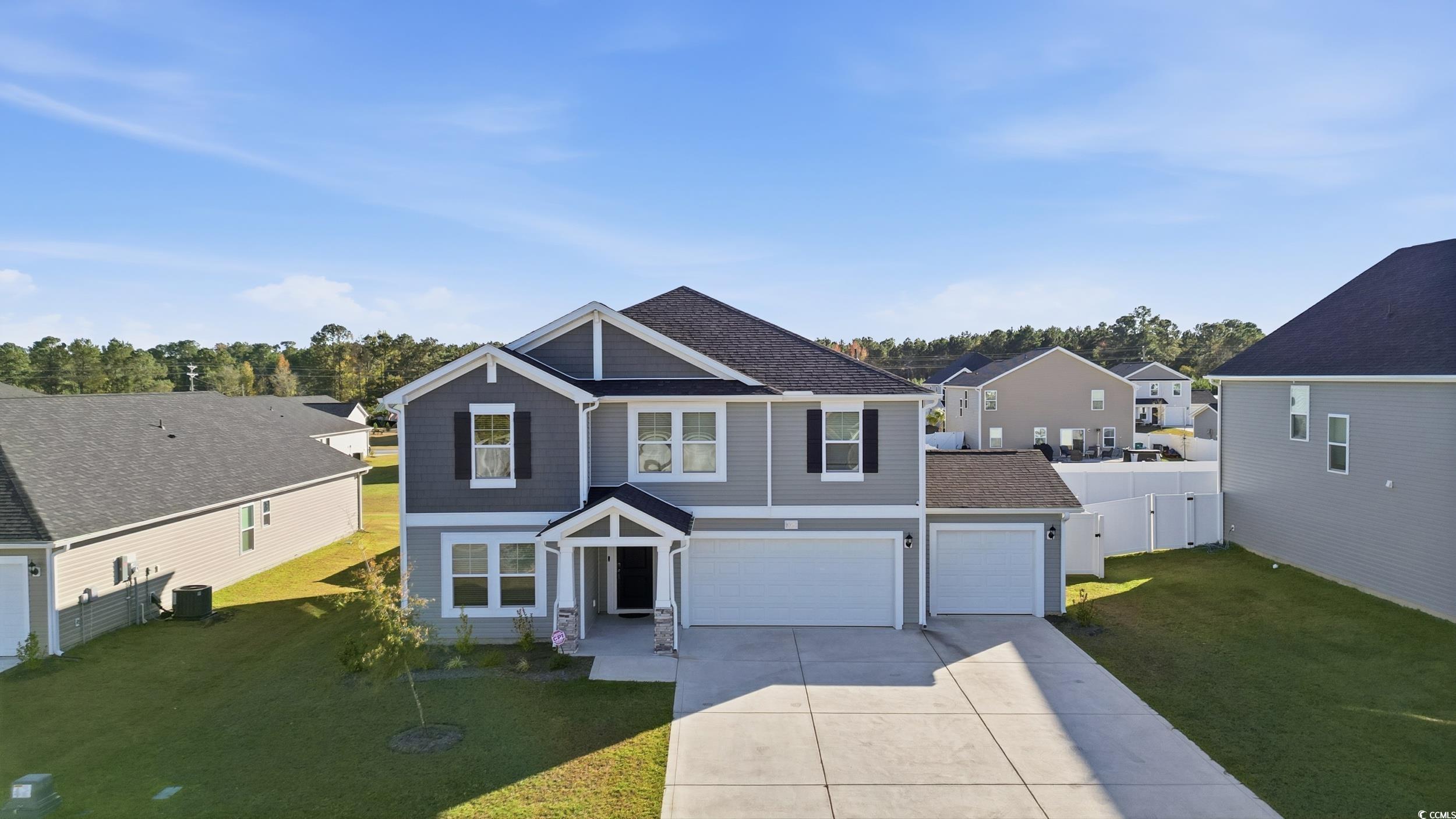 Craftsman-style house featuring concrete driveway, a residential view, a shingled roof, and an attached garage