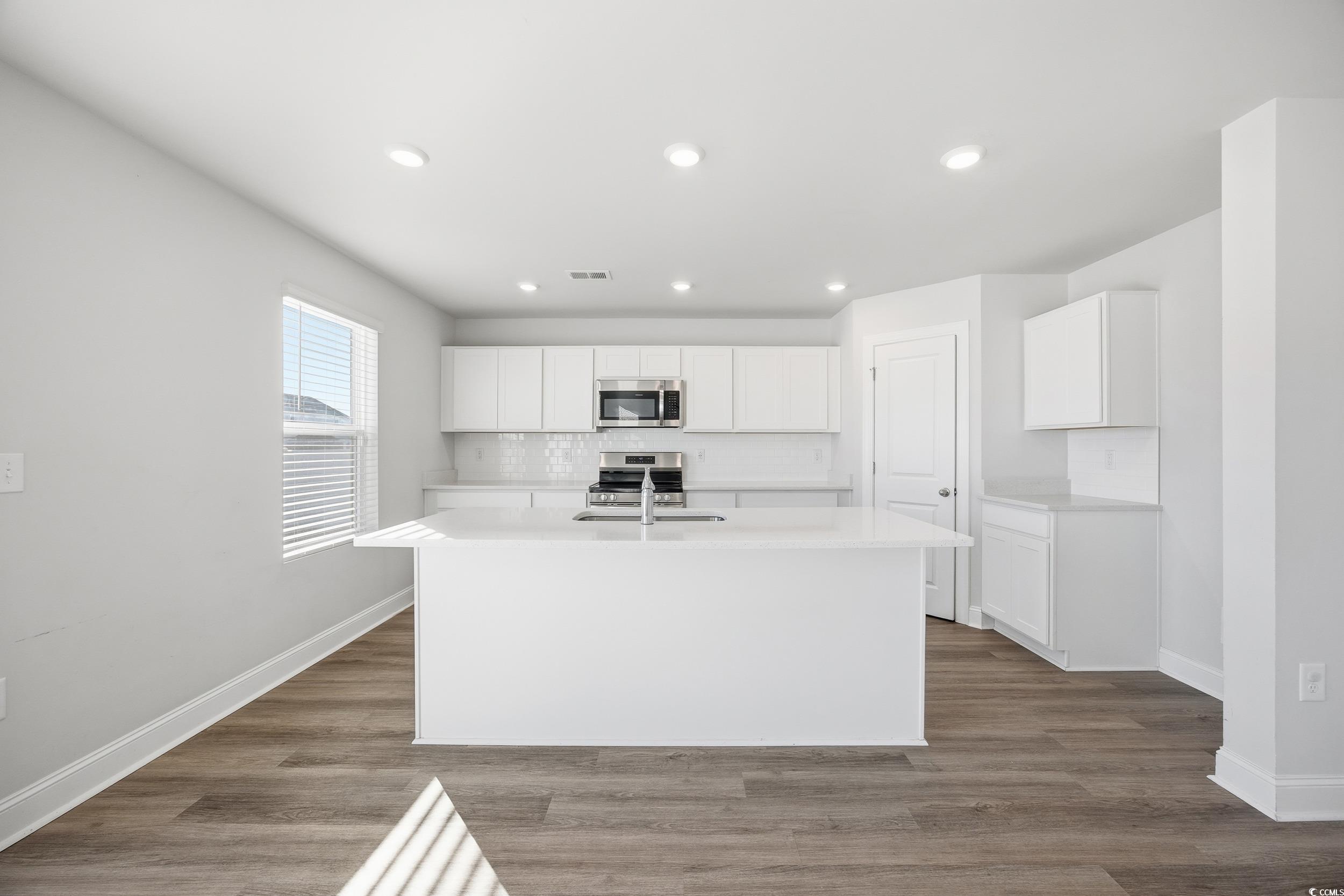 1052 Kinness Drive Conway, SC 29527 - Photo 10 of 38 Kitchen featuring a kitchen island with sink, decorative backsplash, white cabinets, light wood finished floors, and recessed lighting