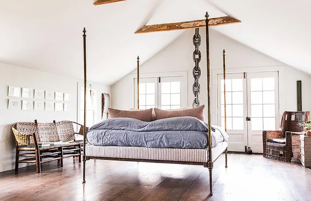 a spacious bedroom with a bed a table and chair with the wooden floor