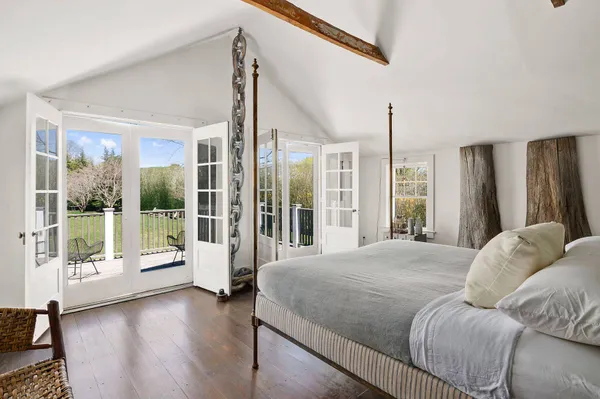 a spacious bedroom with a large bed and glass door