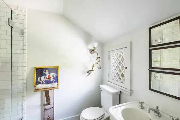 a bathroom with a toilet sink and mirror