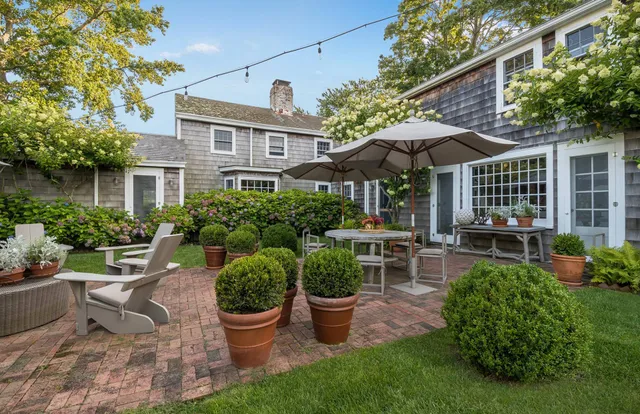 a view of a patio with chairs and potted plants