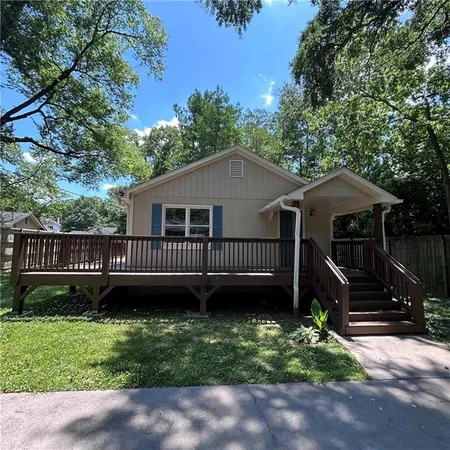 a view of a house with a yard and a wooden deck
