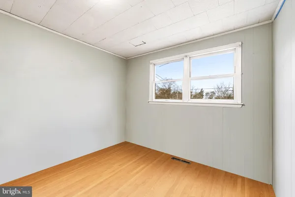 a view of empty room with wooden floor