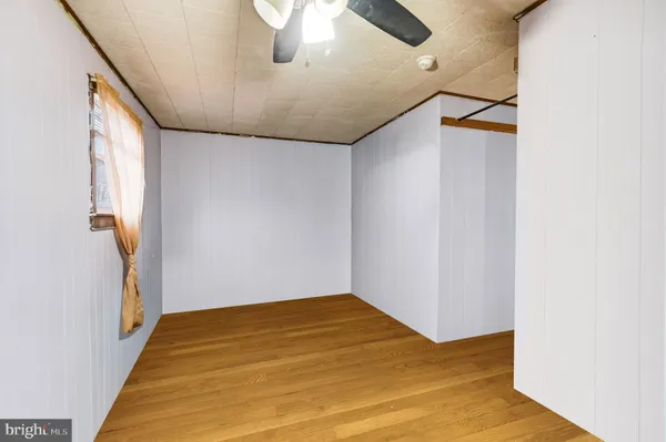 a view of a big room with wooden floor and windows