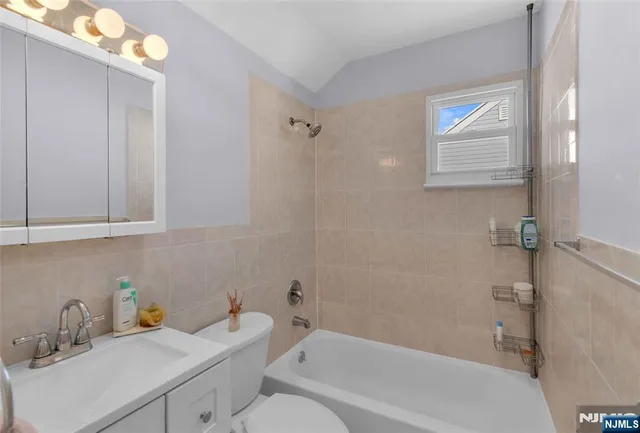 a bathroom with a sink mirror vanity and bathtub