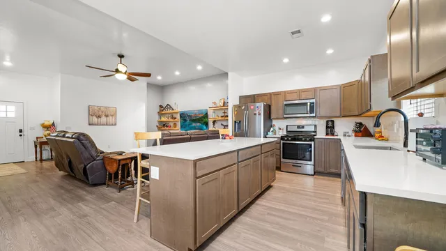 a kitchen that has a lot of cabinets a sink and wooden floor