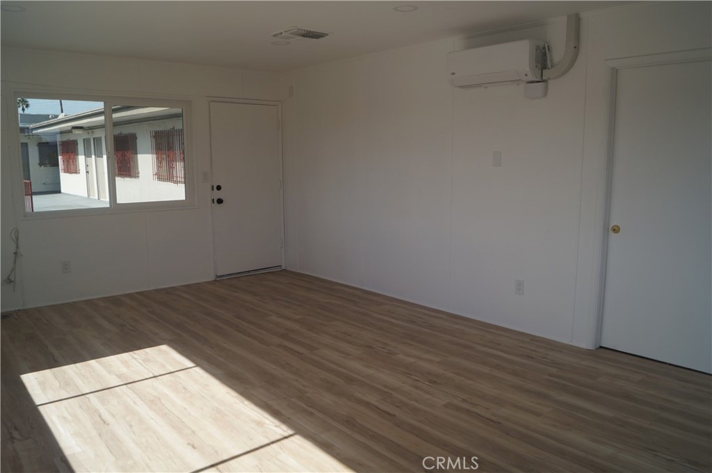 1501 North Sepulveda Boulevard, Unit A Manhattan Beach, CA 90266 - Photo 5 of 5 an empty room with wooden floor and windows