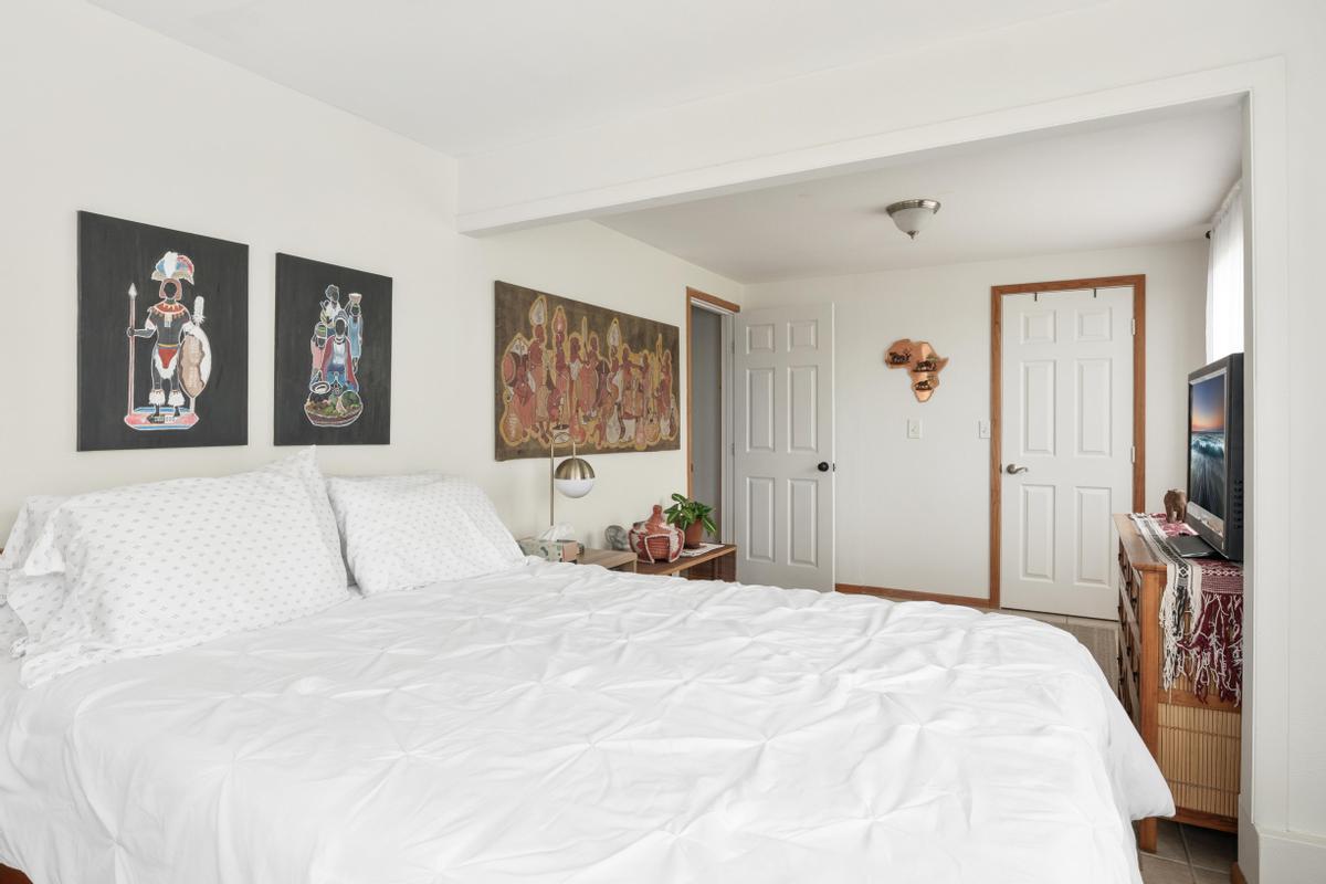 85-4563 Hawaii Belt Road Captain Cook, HI 96704 - Photo 27 of 30 a bedroom with a large bed and a chandelier