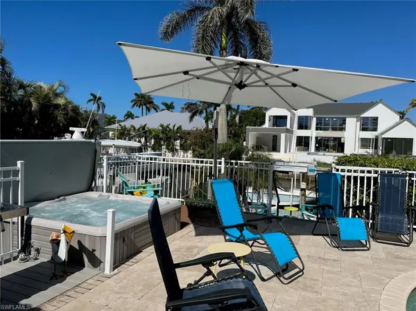 a view of a patio with couches table and chairs under an umbrella