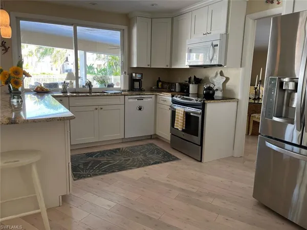 a kitchen with a sink window and cabinets