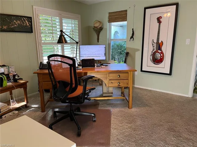 a view of a workspace with furniture and a window