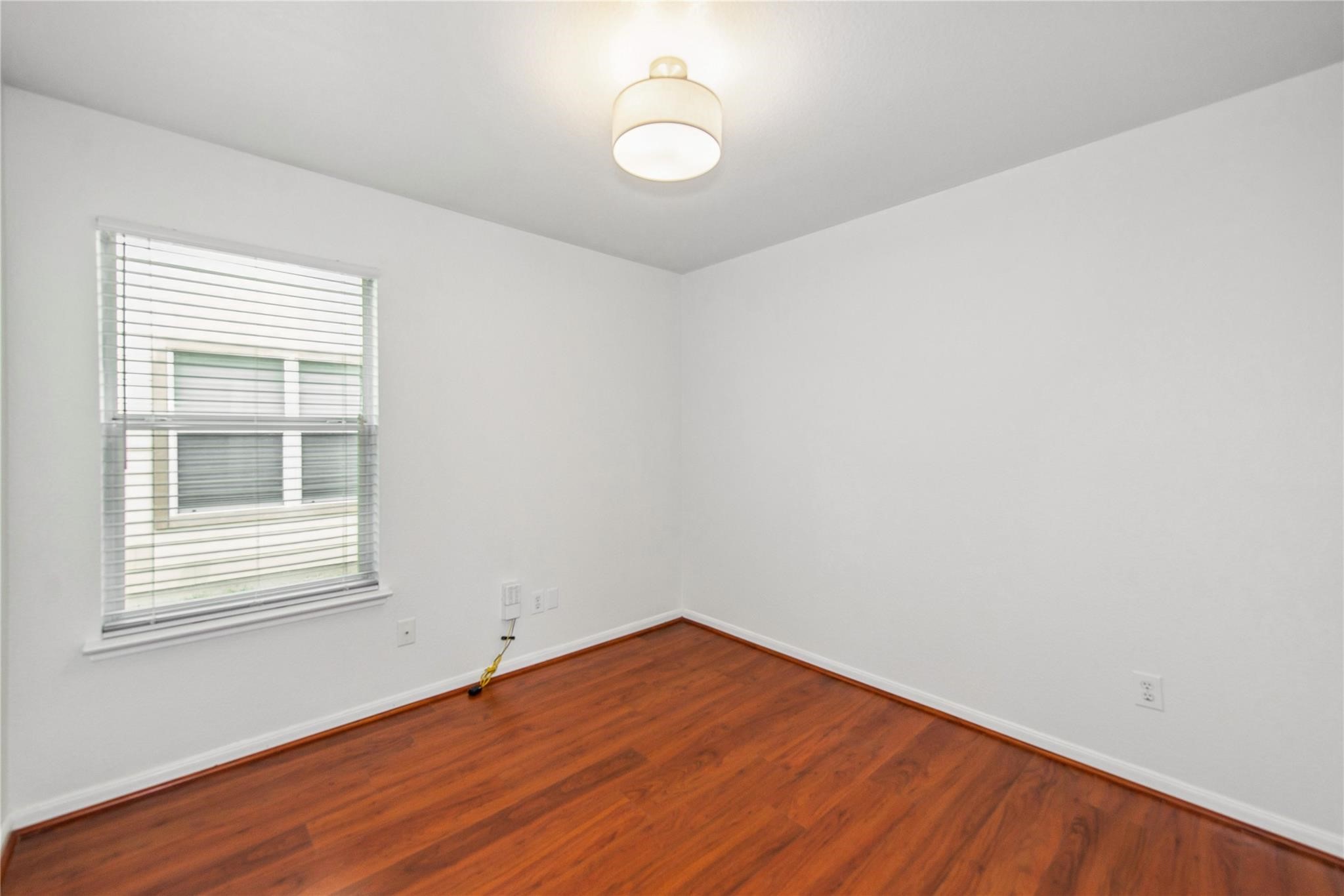 16310 Chandler Ridge Lane Cypress, TX 77429 - Photo 11 of 25 a view of an empty room with wooden floor and a window
