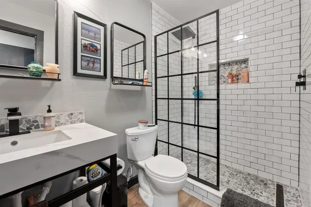 a bathroom with a sink a toilet and shower