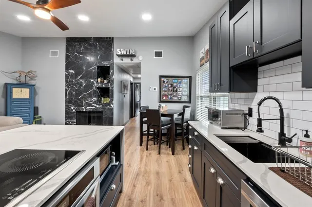 a kitchen with stainless steel appliances granite countertop a sink a stove and a wooden floors