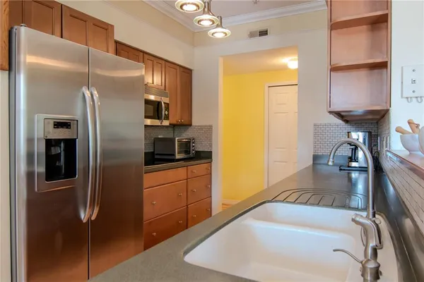 a kitchen with stainless steel appliances granite countertop a refrigerator and a sink