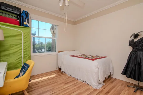 a view of a bedroom with wooden floor and a window
