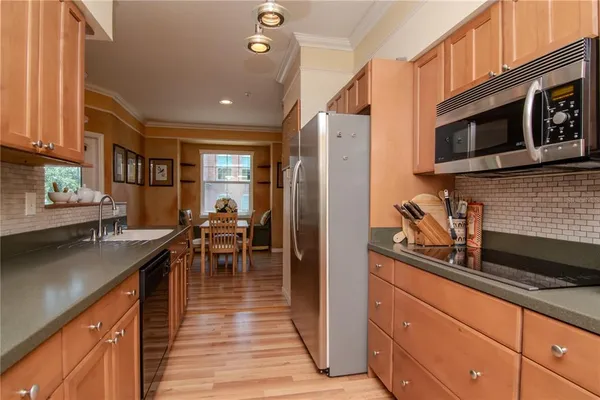 a kitchen with stainless steel appliances granite countertop a refrigerator and a stove top oven