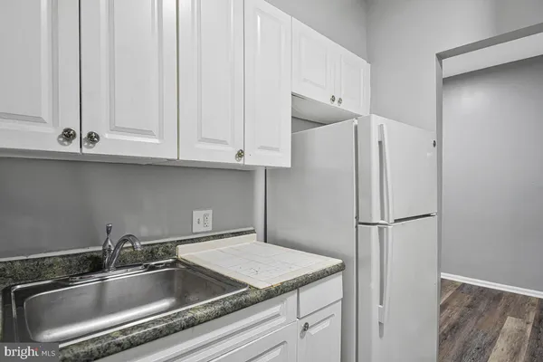 a kitchen with stainless steel appliances white cabinets and a refrigerator