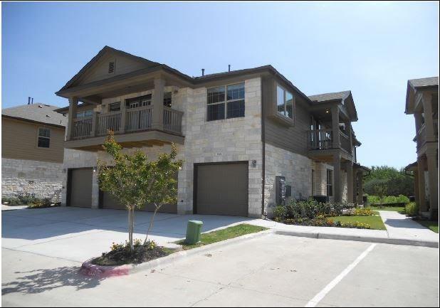 1310 West Parmer Lane, Unit 1503 Austin, TX 78727 - Photo 1 of 26 View of front facade with a balcony, a garage, stone siding, and concrete driveway