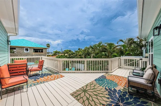 a balcony with wooden floor and outdoor seating