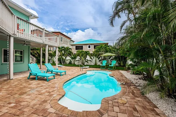 a view of a house with backyard porch and sitting area