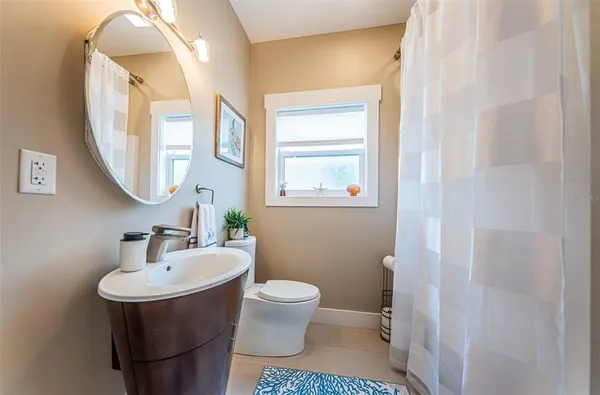 a bathroom with a toilet sink and mirror