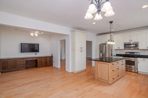 a kitchen with stainless steel appliances a stove refrigerator and microwave