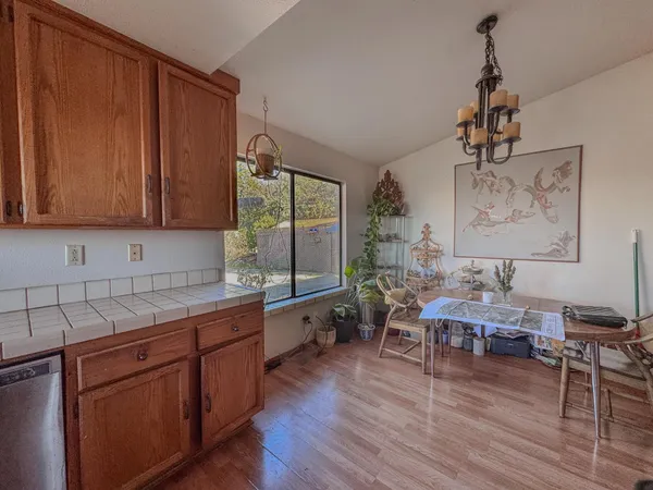 a kitchen with stainless steel appliances granite countertop wooden cabinets a sink and dishwasher with wooden floor