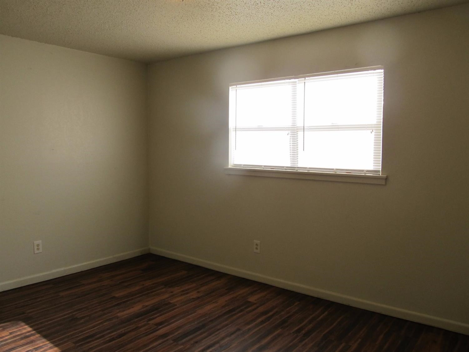 4516 35th Street, Unit B Lubbock, TX 79414 - Photo 5 of 7 an empty room with wooden floor and windows
