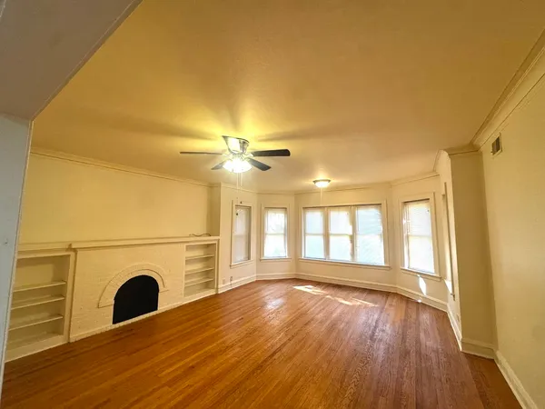 a view of a livingroom with wooden floor and a fireplace