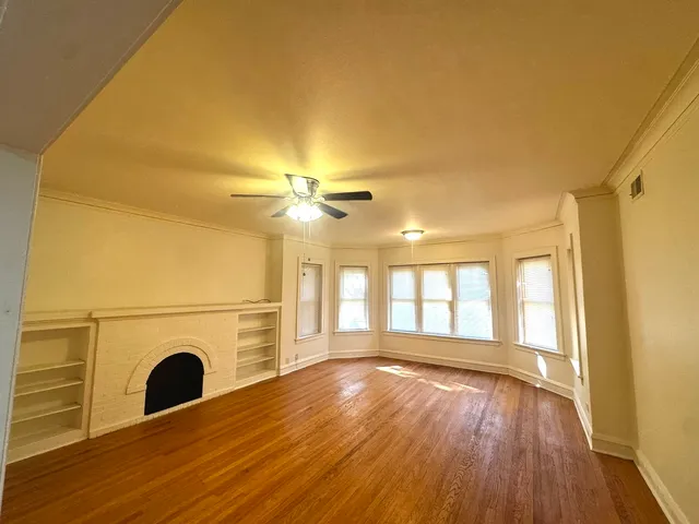 a view of a livingroom with wooden floor and a fireplace