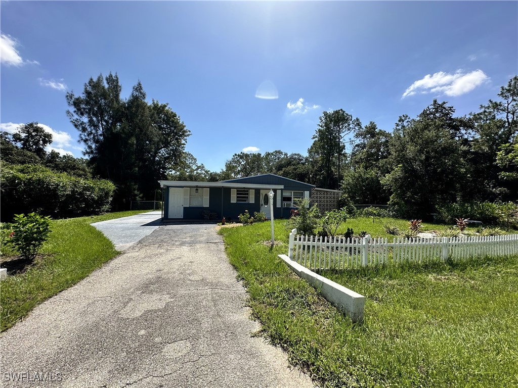 818 Sheldon Avenue Lehigh Acres, FL 33936 - Photo 1 of 43 a front view of a house with a yard and potted plants