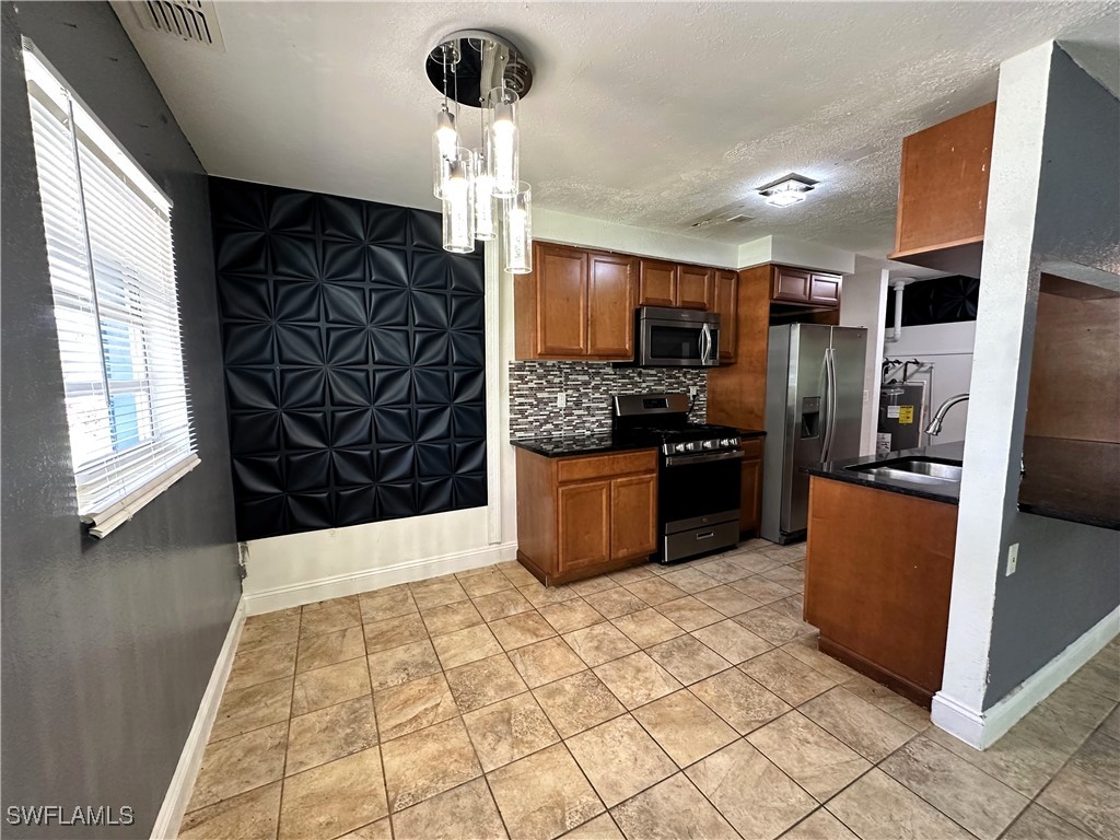 818 Sheldon Avenue Lehigh Acres, FL 33936 - Photo 11 of 43 a kitchen with stainless steel appliances a refrigerator and a stove